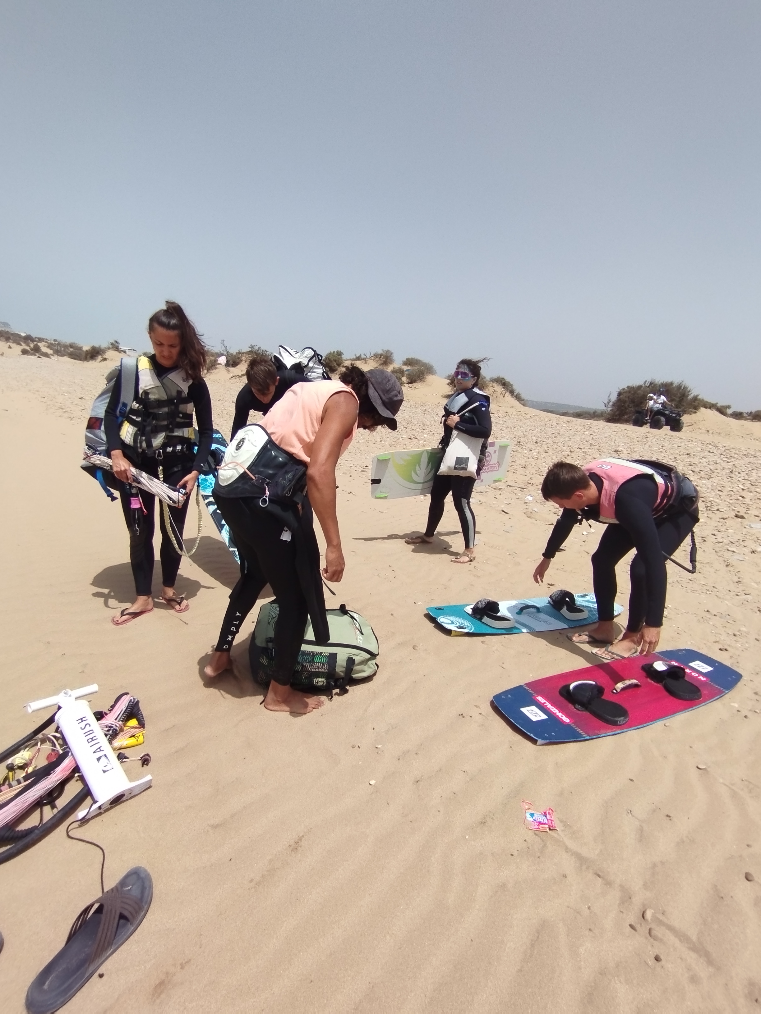 Students preparing boards and gear on the sand